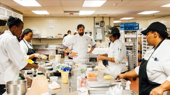 A crew of people making food in a commercial kitchen