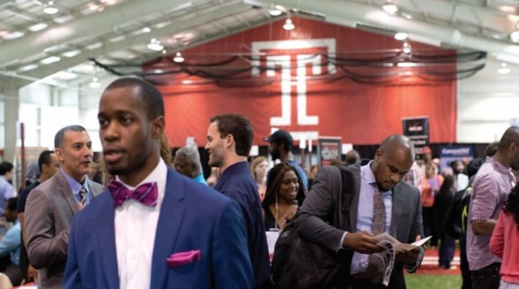 People at an event with the Temple University symbol in the background