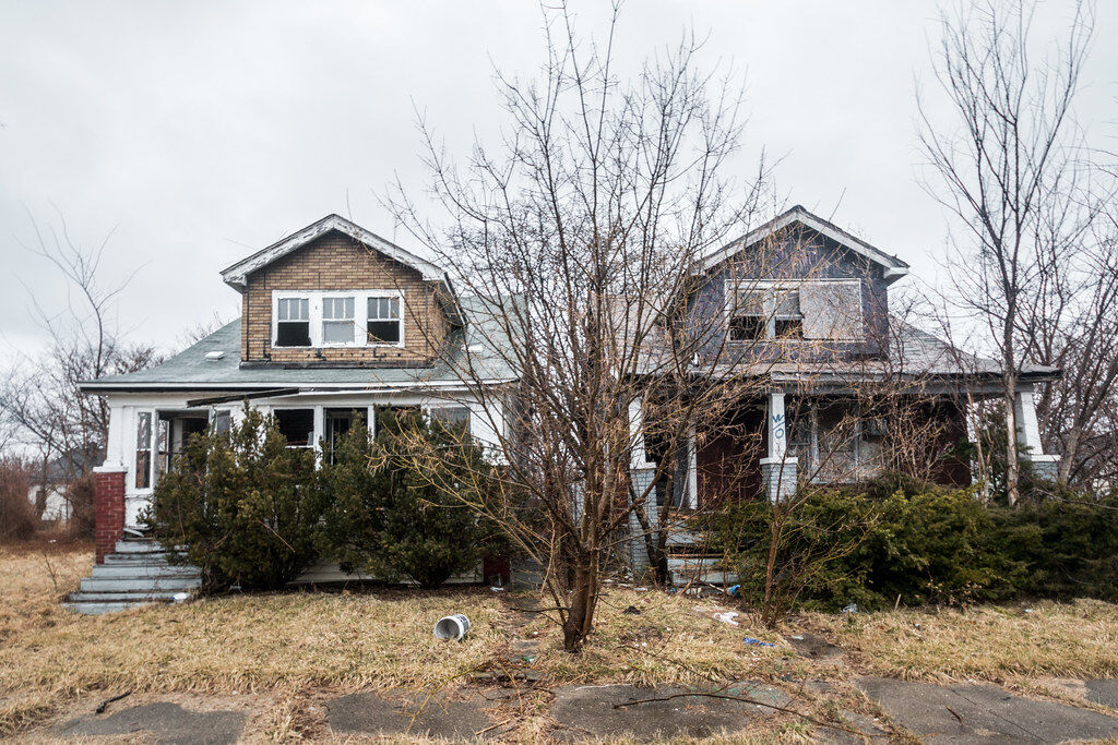 2 abandoned houses with overgrown yards