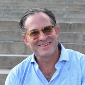 Jeff Hornstein, Executive Director. Sitting on the steps where brown glasses and a light blue button up collared shirt.