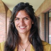 Latina Woman smiling in yellow blouse.