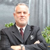 White man in black suit wearing red tie