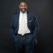 black man in suit with hands in suit pocket