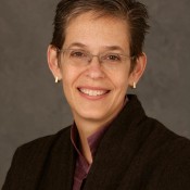 white woman smiling and wearing glasses