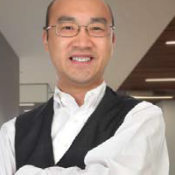 Asian man smiling in white long sleeve and black vest