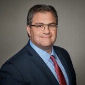 white man in blue shirt and red tie