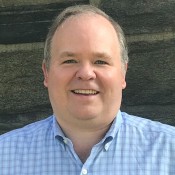 WHITE MAN SMILING IN BLUE SHIRT