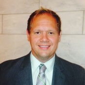 white man smiling in tie and blazer