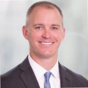 WHITE MAN SMILING WEARING BLUE TIE