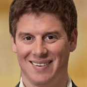 white male smiling with brown hair in white shirt