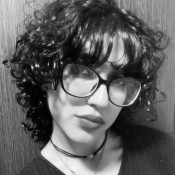 curly dark haired woman with glasses