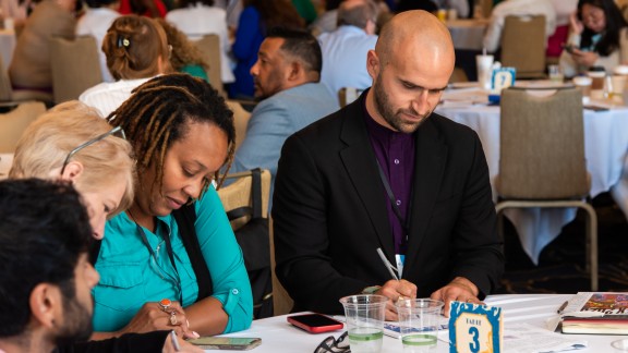 A group of GPLEXers work at a table