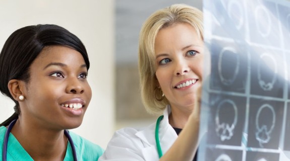 A white person and a Black person looking at a medical chart