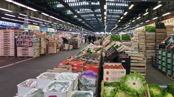 A warehouse full of stacks of boxes of fruits and vegetables