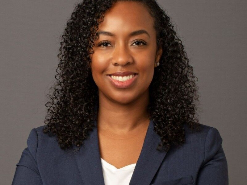 women wearing navy blazer smiling